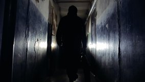 Unrecognizable Burglar Wearing Black Jacket and Carrying a Bag Walking Away From the Camera Along Corridor in Old Apartment Building Criminal Concept - Powered by Shutterstock - Get 15% off with code: PIKWIZARD15
