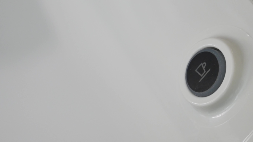 The finger of a boy who presses the flashing power button of the Italian espresso coffee machine.