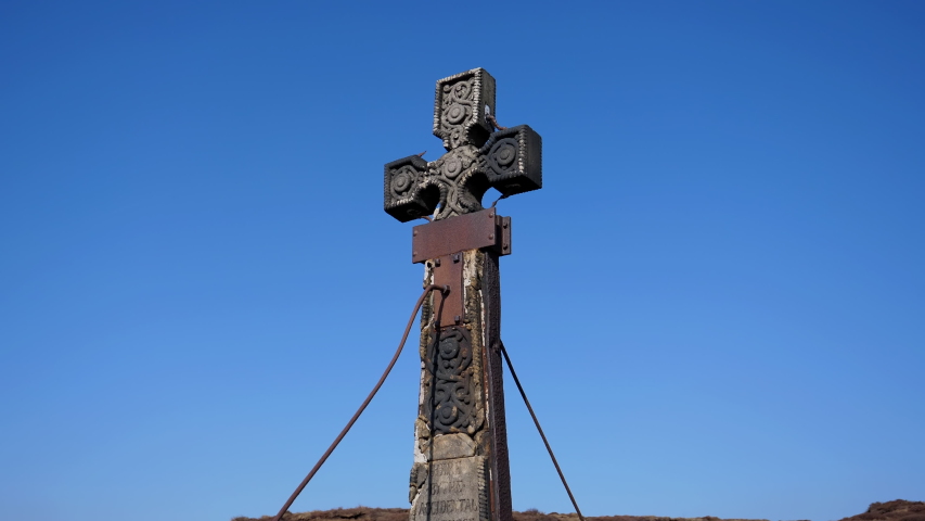 Old weathered 19th century Ashworth Cross memorial to James Platt MP dated 1857 on the top of the Dove Stone Moss hill overlooking Dovestone reservoir. Handheld camera tilt down.