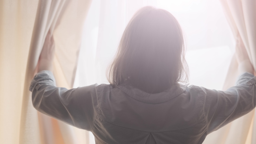 Woman silhouette opening curtains at morning. Warm morning light. Hands pulling window curtain. 4K, UHD | Shutterstock HD Video #1053836354