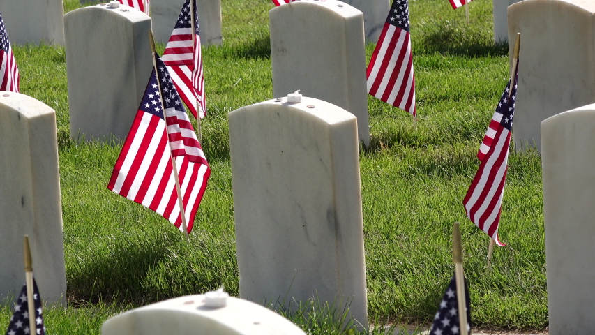 American Flags adorning military headstones at cemetery for Memorial Day