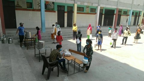 Delhi, Delhi / India - June, 06, 2020 : Cooked food being distributed at Girls Primary School to poor and needy villagers during Covid19 lockdown maintaining social distancing.