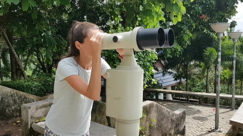 Young woman looking through binoculars
