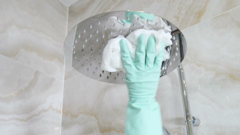 Cleaning chrome-plated bathrooms, shower, bidets. polishing crane and handles. Cleaning in hotel. Close-up shot of maid from hotel staff wiping bath handles, bathtub in toilet. 4k video