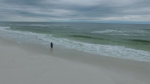 PENSACOLA, FLORIDA - APRIL 22, 2019: Single Person in Pensacola Beach and Sea in Background. Florida