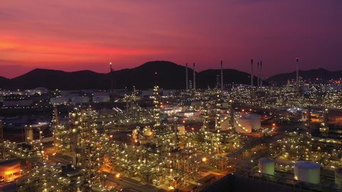 Aerial view at the refinery and oil tank at dusk. Business and petrochemical plants, oil storage tanks and for energy and steel pipes in Twilight time
