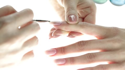 manicurist applying nude nail polish. manicure process. Application of nail polish on nails.