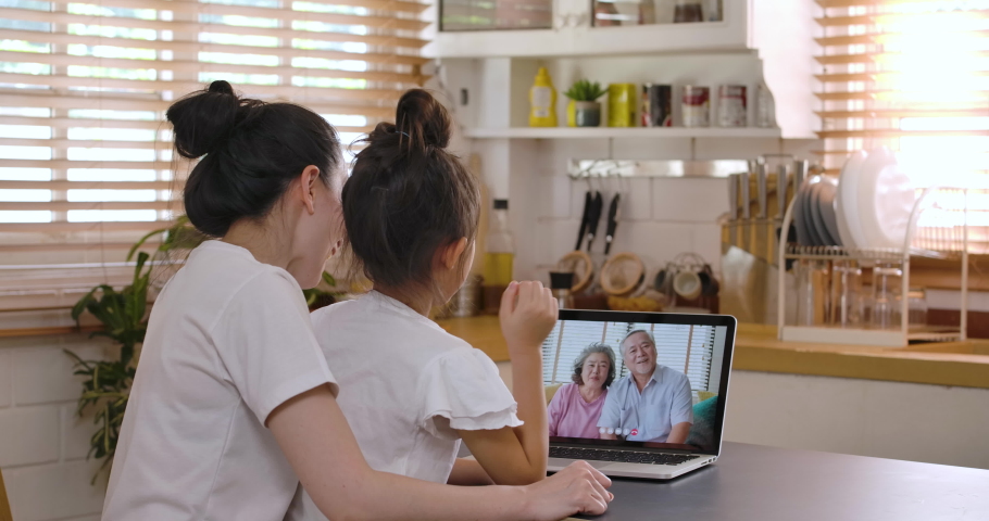 Happy yound asian mother and daughter video calling old senior parents talking with grandparents mom dad in webcam conference chat application on laptop screen on table. Family videocall concept. Royalty-Free Stock Footage #1053894227
