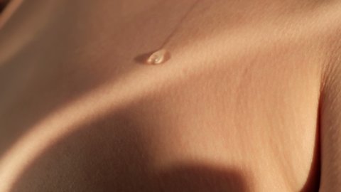 A drop of water or sweat flows over the skin, close-up