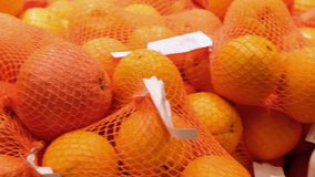 4k Footage ripe orange fruits in food aisle at supermarket.Buy natural fruit for healthy nutrition.Video of oranges and mandarins packed in transparent packaging in foods market.
