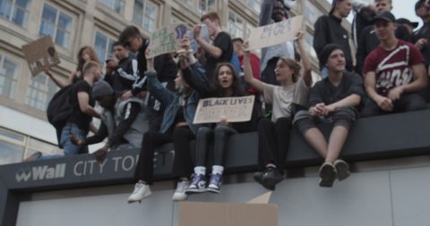 Group of young Protestors holding up signs against Police Brutality Black Lives Matter Deomonstration in Berlin, Germany June 6th 2020