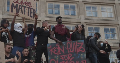 Group of young Black and Caucasian Protestors holding up signs against Racism Black Lives Matter Deomonstration in Berlin, Germany June 6th 2020