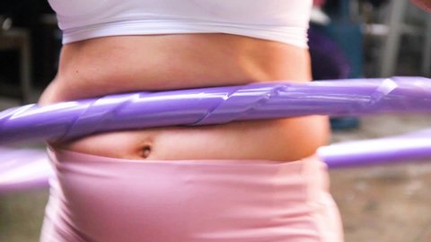 Close up a belly mother postpartum exercise with hula hoop to reduce belly, lose weight.