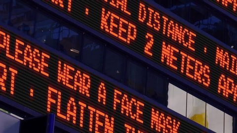 Closeup view of a news ticker reminding pedestrians to keep 2 meters apart from each other. Social distancing was a common practice to slow the spread of COVID-19 during the pandemic of 2020.  	