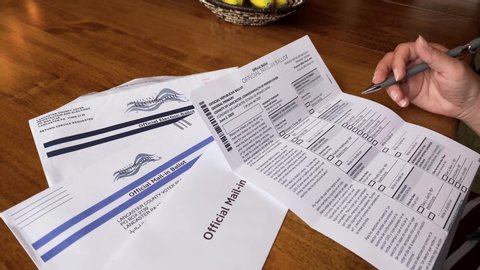 Lancaster , PA / United States - 05 23 2020: Female voter reviews official mail in absentee voter ballot