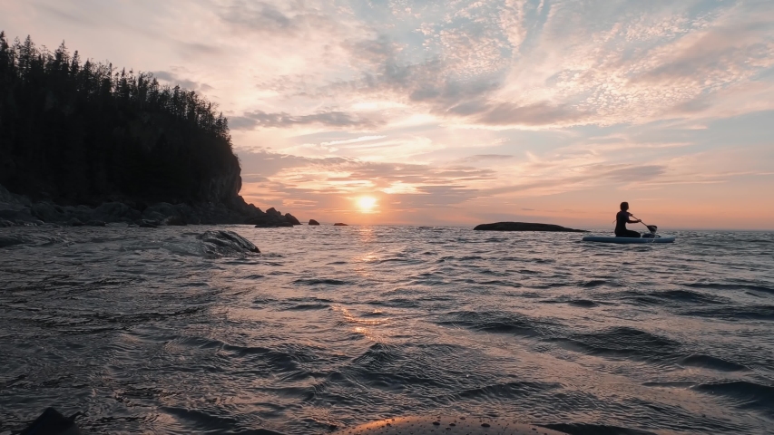 Gorgeous orange sunset on the st-lawrence river in Quebec, Canada in the Bic National Park, with clear and movemented water with a calm feel. - action cam shot Royalty-Free Stock Footage #1053916721