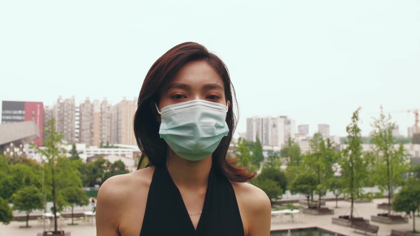 Slow motion of pretty asian woman take off mask looking at camera smile coronavirus Covid-19 pandemic is over Royalty-Free Stock Footage #1053917342