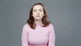 Video of angry woman in pink turtleneck