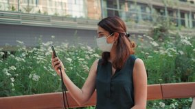 Lifestyle during covid-19, quarantine. Young woman in medical protective mask making selfie during walking in summer park, video chat conference with friends, tourist after covid
