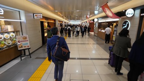 TOKYO - APRIL 06, 2018: Unidentified people walk along passage, dinning area at basement floor of Tokyo Station. Wide angle shot, camera move forward. Many restaurants and cafes at Nippon Gourmet Road