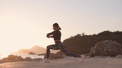 sporty woman jogger stretching on beach with sea view. Athletic runner female stretching on beach. Healthy lifestyle.