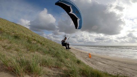 Speed paraglider soaring in Netherlands beach at sunny day