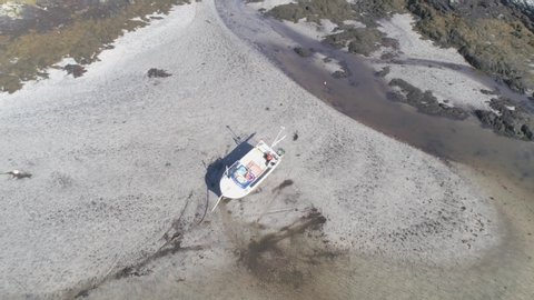 areal drone shot of boat stuck in the sand of the beach with waves. Barra Island Outer Hebrides. Scotland.