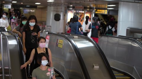 Taipei, Taiwan-04 June, 2020: 4K, Asian people wearing protective mask against transmissible infectious diseases in subway entrance escalator leading into train station. Coronavirus protection-Dan
