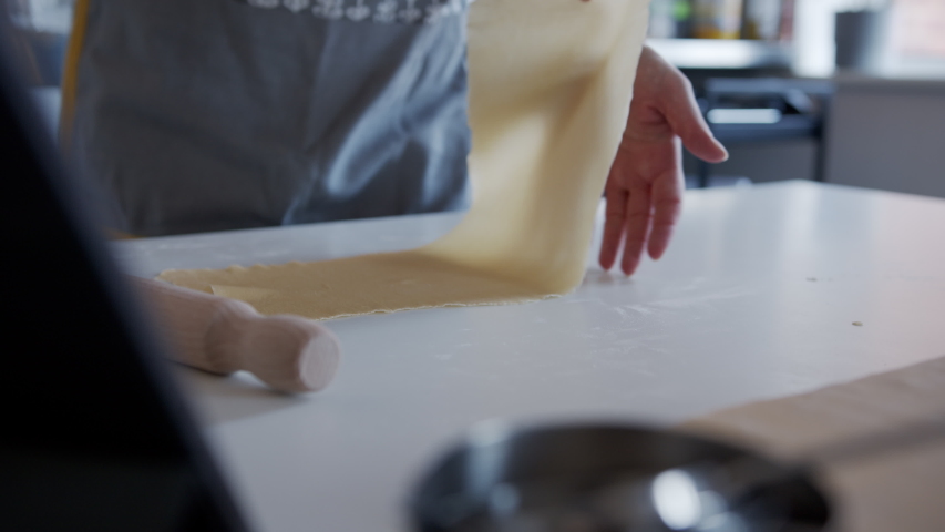 Anonymous Woman, Sprinkling Flour onto Thin Pasta Dough at home. Moving shot. | Shutterstock HD Video #1053953600
