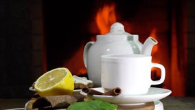 Cozy Fireplace,teapot and cup of Tea with lemon amd mint in a country house.