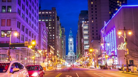 Philadelphia, Pennsylvania / USA - March 28, 2019: A time-lapse of evening rush hour traffic racing through Downtown Philadelphia, with the City Hall Clocktower in the background.