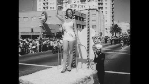 CIRCA 1957 - Contestants wave from their individual parade floats in a parade preceding the Miss Universe beauty pageant.