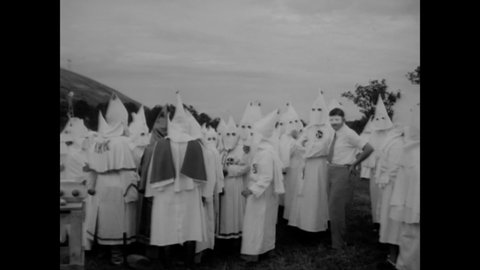 CIRCA 1949 - A child is held up at a Ku Klux Klan rally in Stone Mountain, Georgia, and new members are initiated in a cross burning ceremony.