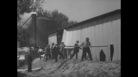 CIRCA 1932 - The Sheriff's deputies destroy a distillery in Downey, California, and puncture containers so the alcohol will pour out.