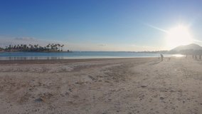 Panoramic view of sea bay and wide abandoned beach with white sand. Sun in the backlight. Winter in Mallorca, Balearic islands, Spain. 4K footage