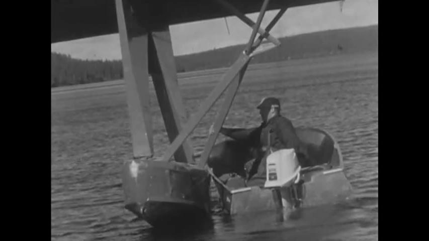 CIRCA 1950s - A woman is guided in a boat from plane to shore, a man drinks coffee from a thermos, and shots of a boat traveling on a river in Canada.
