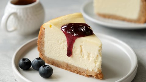 Slice of cheesecake with blueberry sauce. Serving cheesecake with blueberry jam