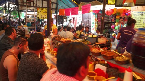 TEPOZTLAN, MEXICO. CIRCA 2019. People eating mexican food in a traditional market. Mexico has a delicious and variety gastronomy recognized worldwide.