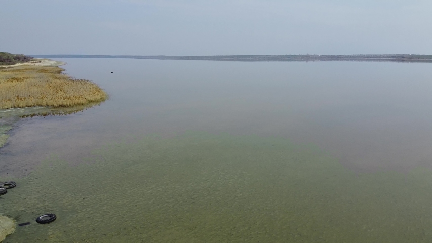 Aerial view, flying over the salty sands of the litoral zone on Kuyalnik Liman. Camera moves backwards above coastline Kuyalnik Estuary, Odessa Oblast, Ukraine