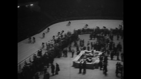 CIRCA 1930 - Bicyclists race on an indoor track in New York City, New York.