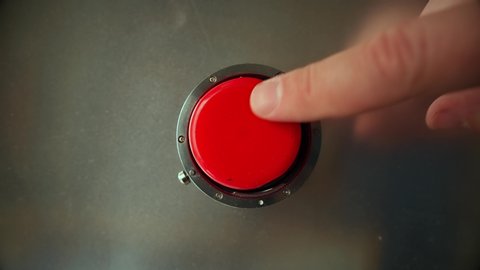 Finger presses the big red button 