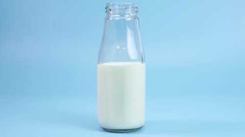 Stop motion animation Fresh milk bottle handle on blue background, Closeup Front view Food concept.