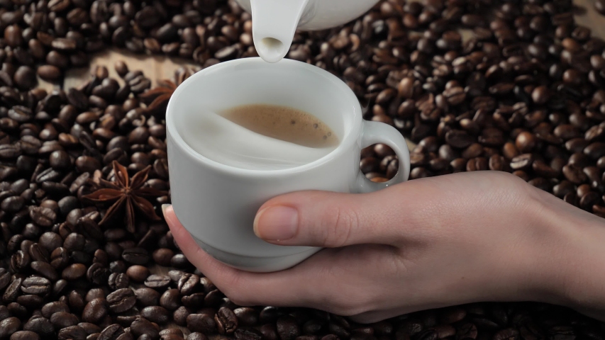 Hot coffee is poured into a cup from a coffee pot. | Shutterstock HD Video #1053980582