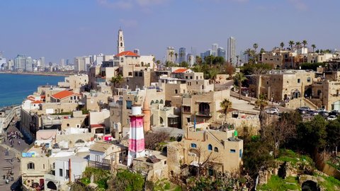 Aerial of Jaffa old city port to Tel Aviv coastline, including St. Peter church bell tower and Tel Aviv skyline in the horizon.