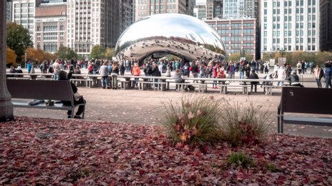 Chicago, IL - November 3rd, 2018: Millennium Park swarms with people on a sunny fall day as tourists and locals hang out at the plaza near the famous Cloud Gate sculpture by Anish Kapoor.