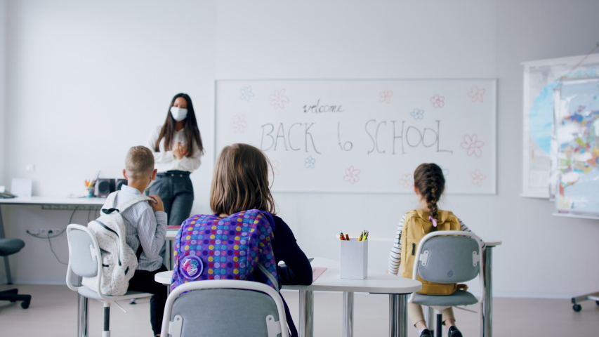 Group of children with face mask back at school after covid-19 quarantine and lockdown. Royalty-Free Stock Footage #1053984605