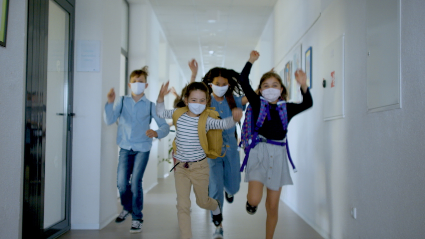 Group of cheerful children going home from school after covid-19 quarantine and lockdown.