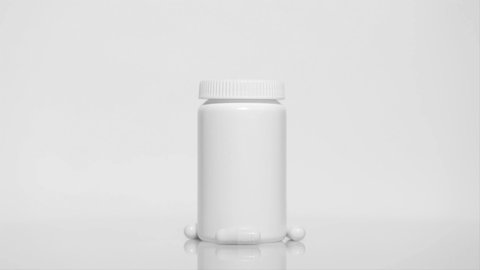 Plastic medical bottle with pills on a white table, rotation 360 degrees. White background.Ultra high definition 3840X2160.4K resolution