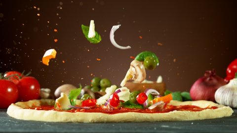 Super slow motion of falling pizza ingredients on yeast dough. Filmed on high speed cinema camera, 1000 fps.