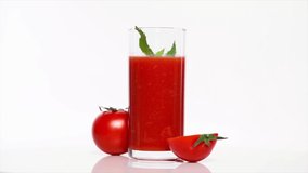 A glass of tomato juice with fresh tomatoes on a white table, rotation 360 degrees. White background.Ultra high definition 3840X2160.4K resolution